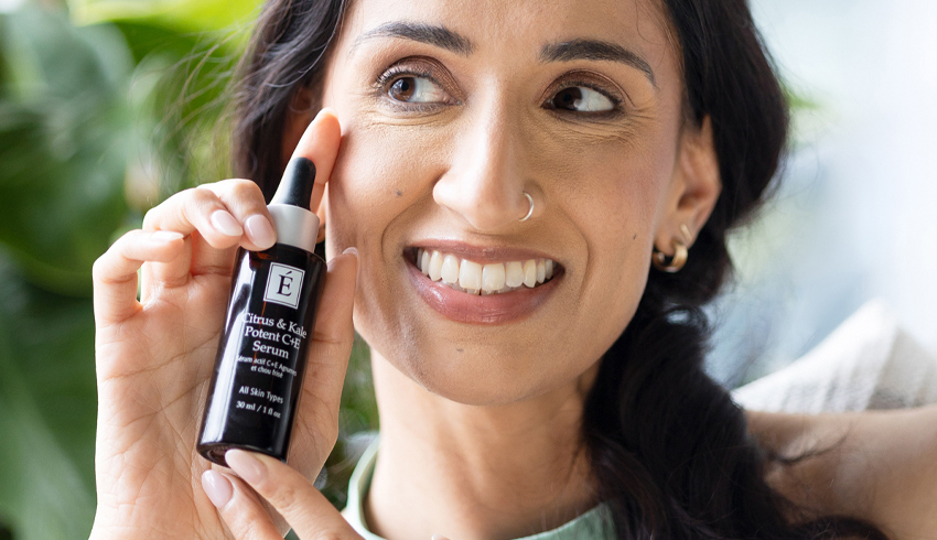 a woman holds a serum bottle in her cupped hand